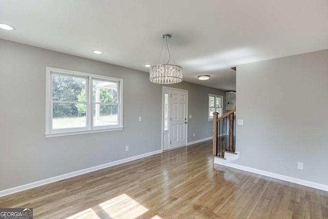 interior space featuring a wealth of natural light, light wood finished floors, baseboards, and stairs