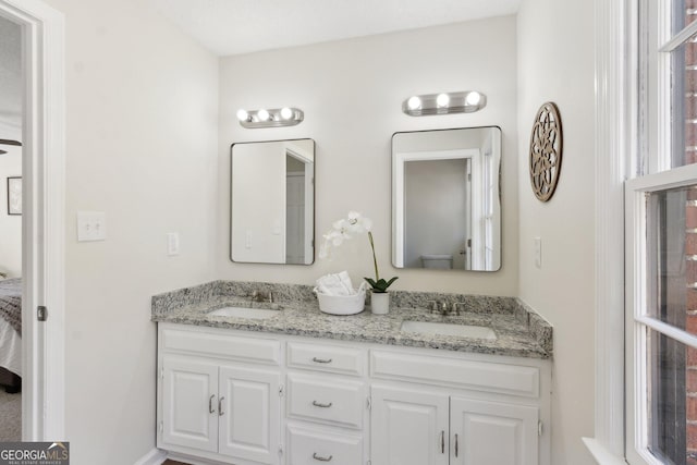 bathroom featuring connected bathroom, a sink, and double vanity