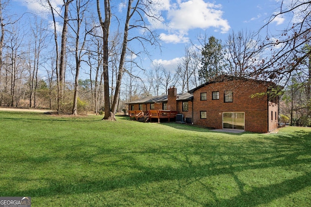 view of yard with central AC unit and a deck