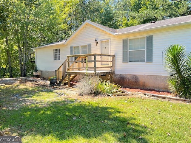 view of front of home with a front yard and a wooden deck