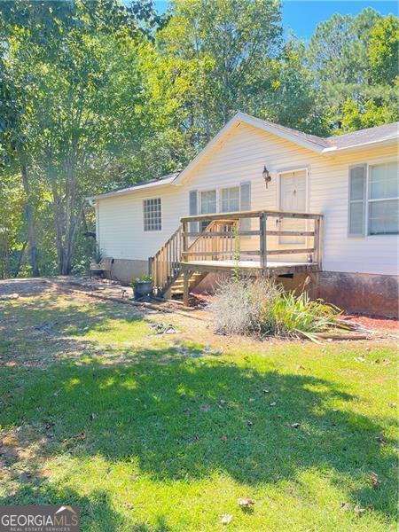 view of front of house featuring crawl space, a front lawn, and a wooden deck