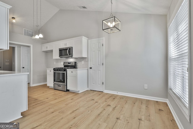 kitchen featuring stainless steel appliances, white cabinets, visible vents, and backsplash