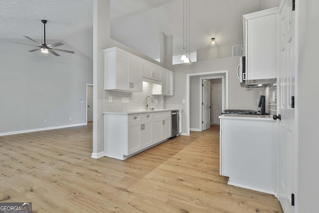 kitchen featuring range, ceiling fan, stainless steel microwave, light countertops, and backsplash