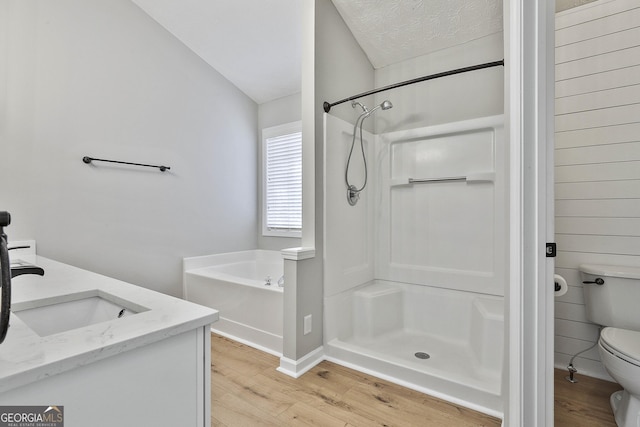 full bathroom with a bath, a shower stall, toilet, and wood finished floors