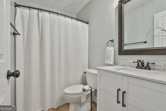 full bath with a textured ceiling, wood finished floors, vanity, and toilet