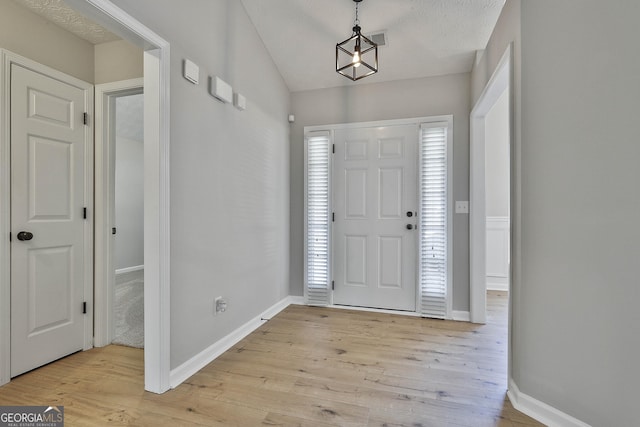 entrance foyer with light wood finished floors, visible vents, and baseboards