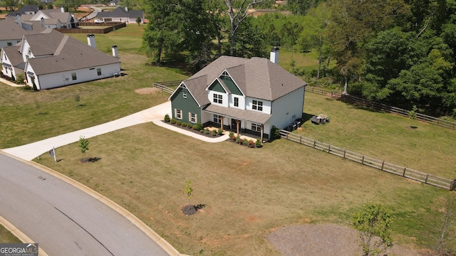 craftsman-style home featuring fence, board and batten siding, roof with shingles, and a front yard