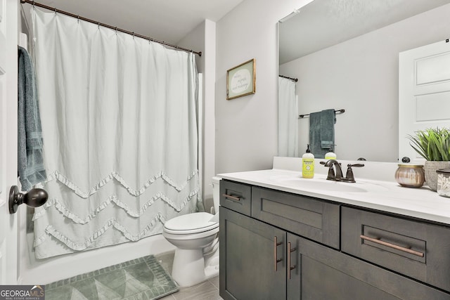 bathroom with shower / bath combo with shower curtain, vanity, and toilet