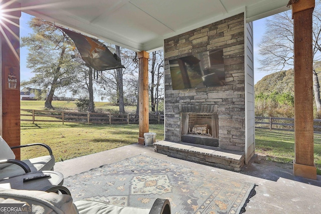 view of patio / terrace featuring an outdoor stone fireplace and fence