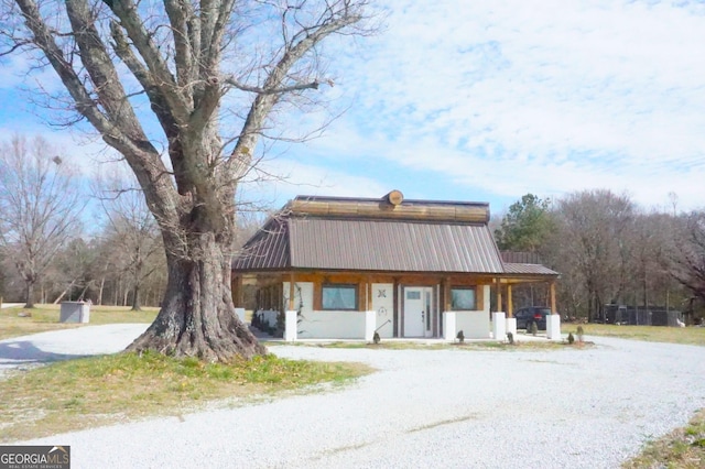 view of front of house with metal roof and gravel driveway