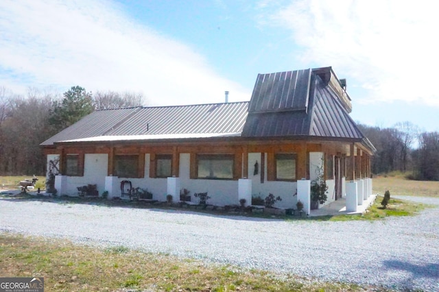 exterior space featuring metal roof and a chimney