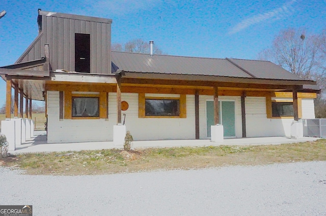 rear view of house featuring covered porch, metal roof, and central AC unit