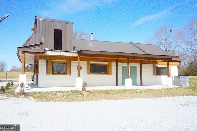 rear view of house with central air condition unit, metal roof, and a porch