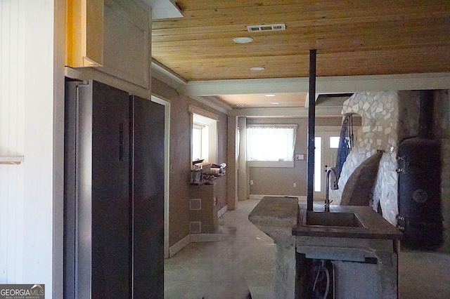 hallway with wood ceiling, visible vents, and a sink