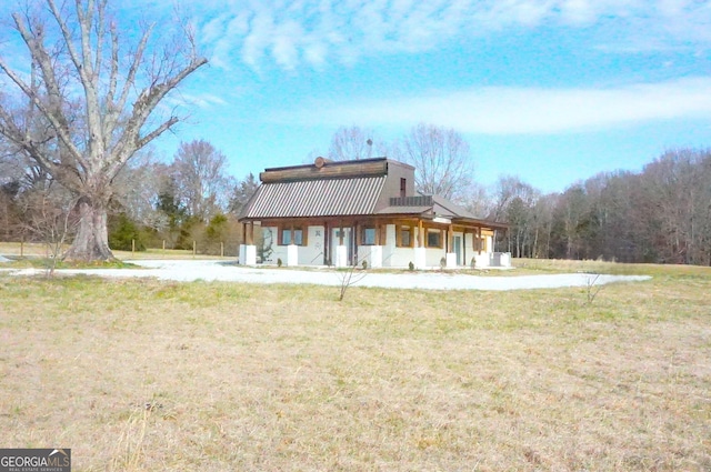 view of front of home with a front yard and metal roof