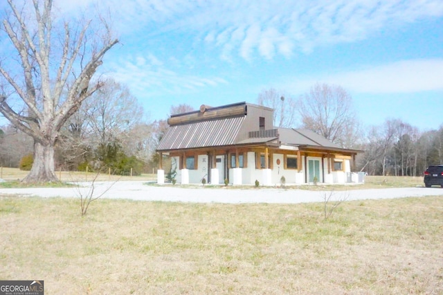 view of home's exterior with metal roof and a yard