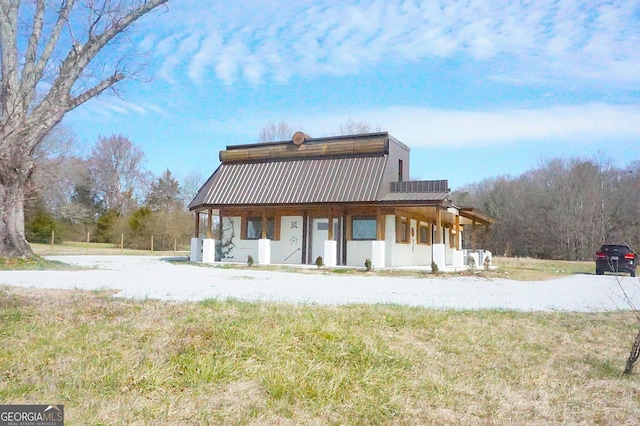 rear view of property with metal roof and a porch