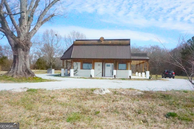 rear view of property with a porch and metal roof