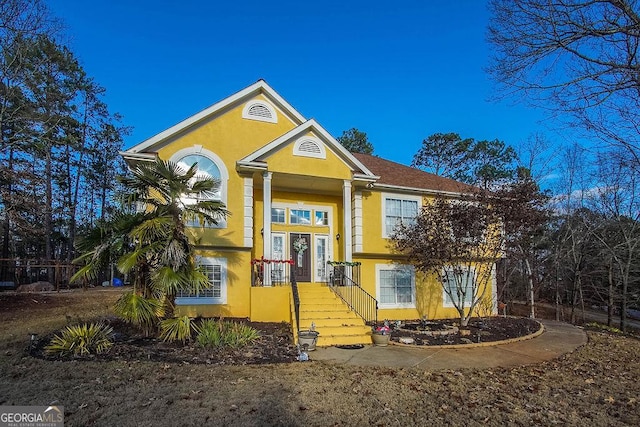 bi-level home featuring french doors and stucco siding