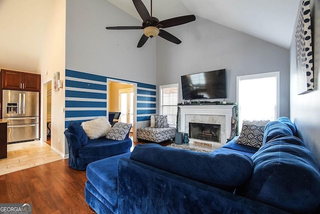 living room with light wood-style floors, a wealth of natural light, a fireplace, and baseboards