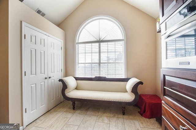 sitting room featuring plenty of natural light, visible vents, and vaulted ceiling