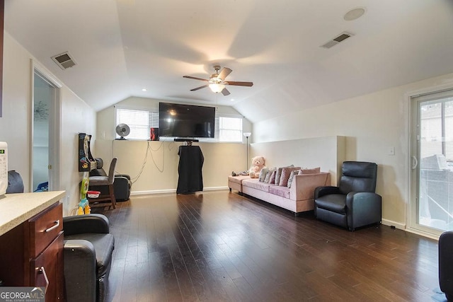 living area featuring visible vents, vaulted ceiling, and dark wood-type flooring