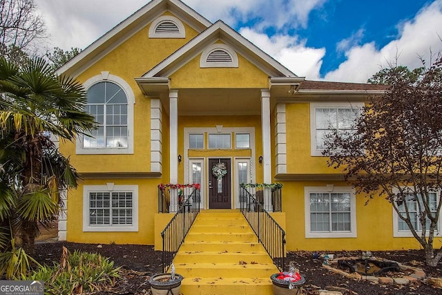 doorway to property featuring stucco siding