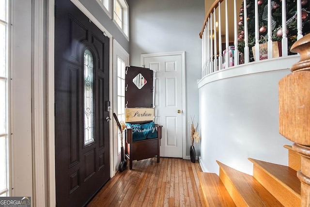 foyer entrance featuring a towering ceiling and hardwood / wood-style flooring