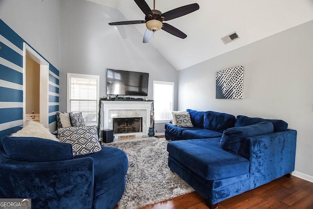 living room with a healthy amount of sunlight, visible vents, baseboards, and wood finished floors