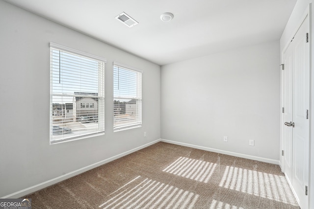 unfurnished bedroom with carpet floors, visible vents, and baseboards