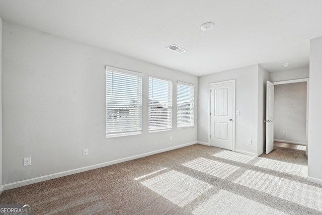 unfurnished bedroom featuring light carpet, visible vents, and baseboards