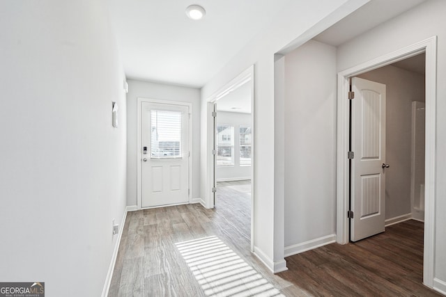 hallway featuring baseboards and wood finished floors