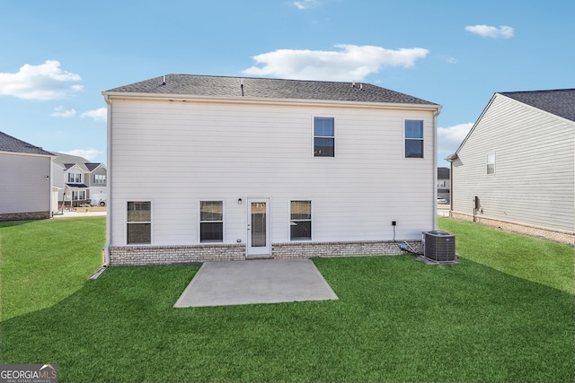 rear view of property featuring brick siding, a patio, central AC, and a lawn