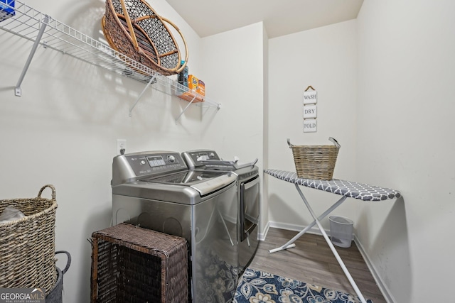 laundry room featuring washer and dryer, laundry area, baseboards, and wood finished floors