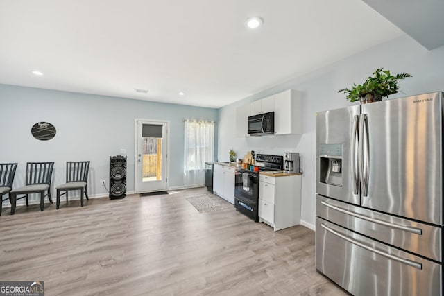 kitchen with recessed lighting, white cabinets, light wood-style flooring, and black appliances