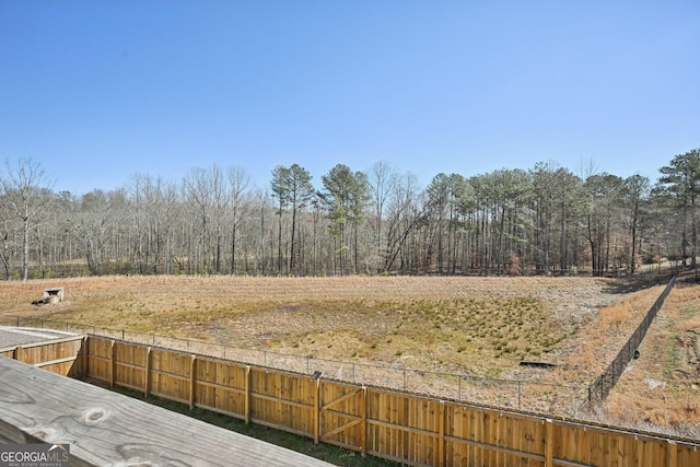 view of yard with fence and a view of trees