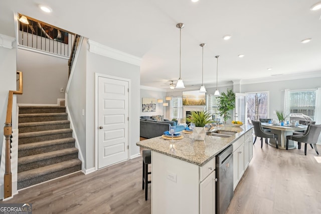 kitchen featuring light wood finished floors, ornamental molding, white cabinets, light stone countertops, and dishwasher