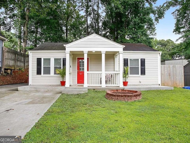 view of front of house featuring a porch, fence, and a front lawn