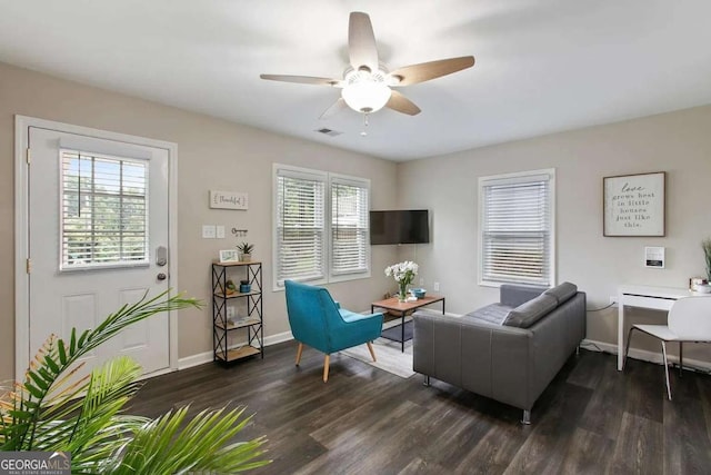 living area with visible vents, baseboards, dark wood finished floors, and a ceiling fan