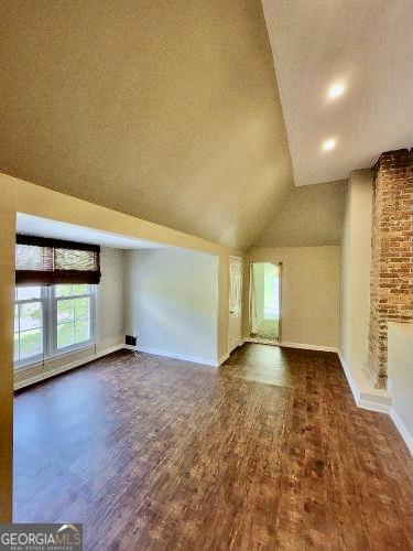 bonus room featuring vaulted ceiling, baseboards, and wood finished floors