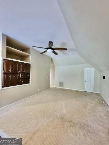 bonus room with lofted ceiling, carpet, and visible vents