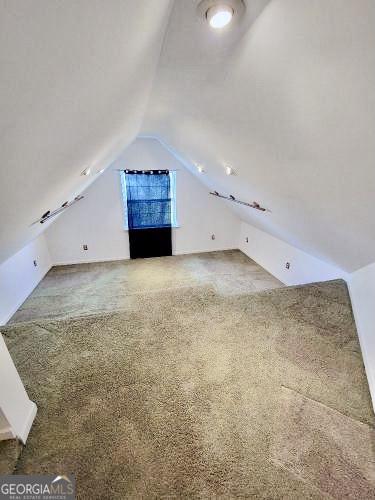 bonus room with lofted ceiling and carpet floors