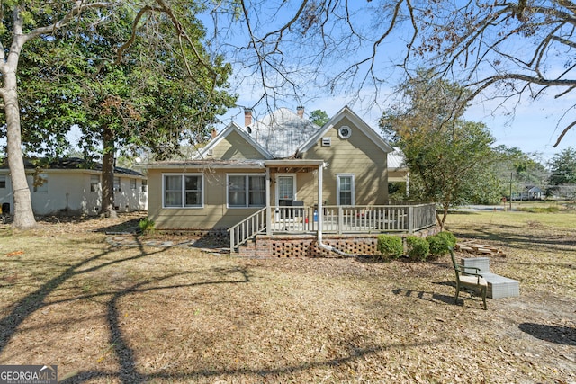 bungalow featuring a chimney and a deck