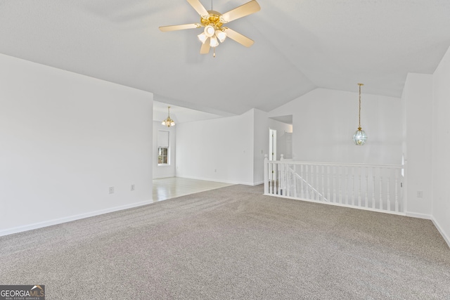 unfurnished living room featuring baseboards, carpet floors, a ceiling fan, and vaulted ceiling