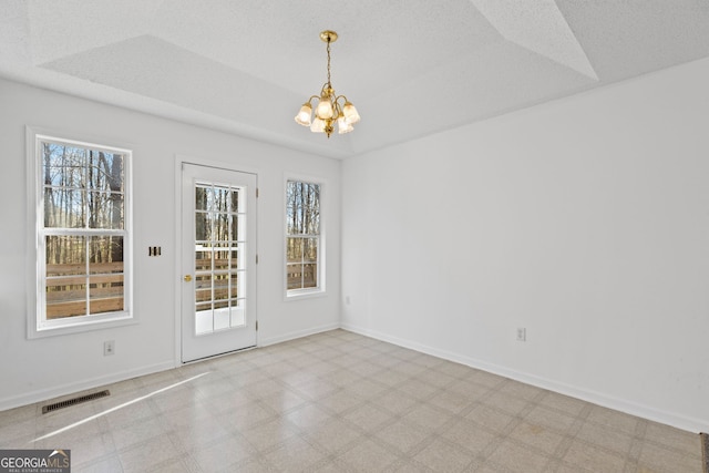 interior space with baseboards, visible vents, tile patterned floors, a raised ceiling, and a chandelier