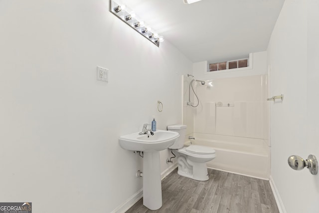 bathroom with shower / bath combination, baseboards, toilet, and wood finished floors