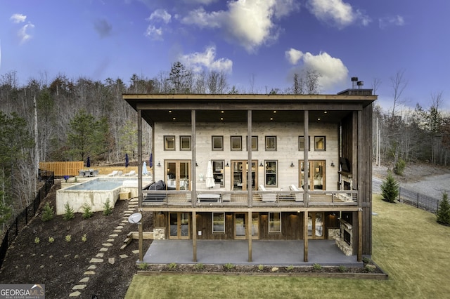 back of property featuring a fenced in pool, a patio area, fence, and french doors