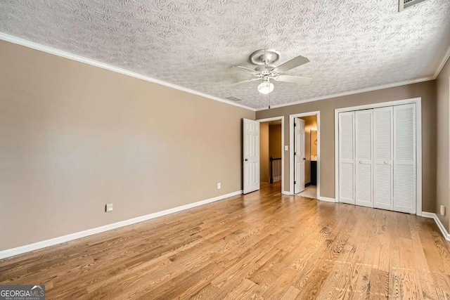 unfurnished bedroom with ornamental molding, light wood-type flooring, connected bathroom, and baseboards