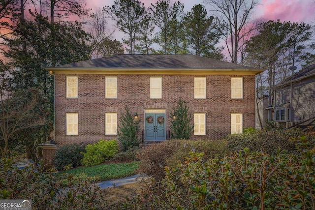 colonial inspired home featuring brick siding