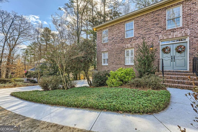 view of front of house with entry steps and brick siding